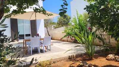 a patio with a table and an umbrella at HANA Holiday house in Ayia Napa