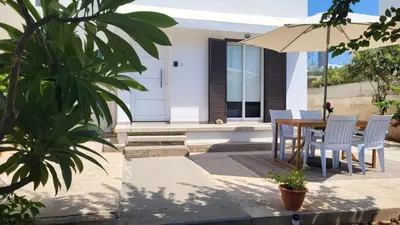 a patio with a table and chairs and an umbrella at HANA Holiday house in Ayia Napa
