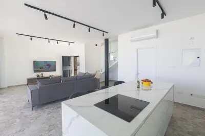 a white living room with a couch and a table at Protaras Aqua Villa AQ05 in Protaras