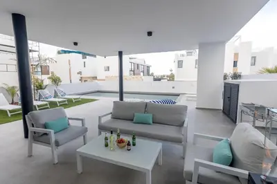 a living room with a couch and a table at Aqua 4 Bedrooms in Paralimni
