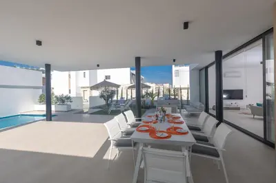 a dining room with a table and chairs on a patio at Aqua 4 Bedrooms in Paralimni