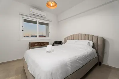 a bedroom with a large bed and a window at Modern seaview apartment in the heart of Agia Napa in Ayia Napa