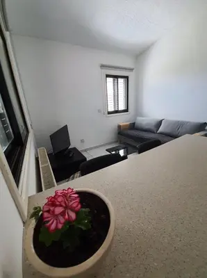 a living room with a table with a flower in a bowl at Bright and Cozy 2-Bedroom Apartment in Strovolos in Strovolos