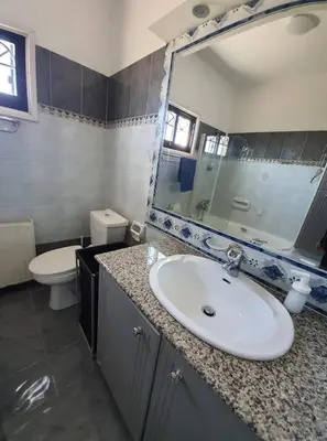 a bathroom with a sink and a mirror and a toilet at Bright and Cozy 2-Bedroom Apartment in Strovolos in Strovolos