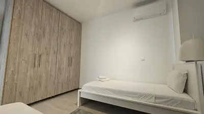 a bedroom with a bed and a wooden cabinet at STAY Larnaca Pearl Apartment in Larnaka