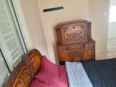 a bedroom with a wooden dresser next to a bed at Big house near sea, shared swimming pool in Voroklini