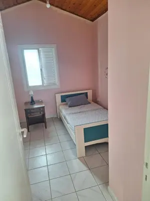 a small bedroom with a bed and a window at Big house near sea, shared swimming pool in Voroklini