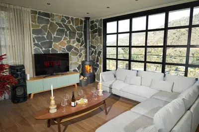 a living room with a couch and a tv at Luxury 5-Bedroom Chalet Kalopanayiotis in Kalopanayiotis