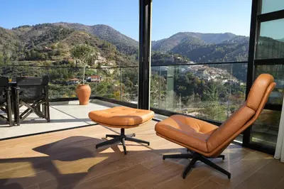 a room with two chairs and a piano on a balcony at Luxury 5-Bedroom Chalet Kalopanayiotis in Kalopanayiotis