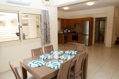 a kitchen and dining room with a table and chairs at Anthorina Villa 21 in Protaras
