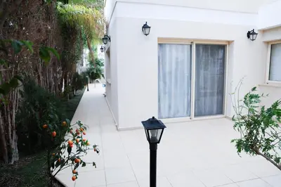 a white house with a street light on the sidewalk at Anthorina Villa 21 in Protaras