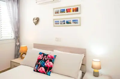 a bedroom with a white bed with white pillows at Jules Apartment in Paralimni