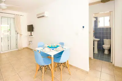 a dining room with a table and blue chairs at Jules Apartment in Paralimni