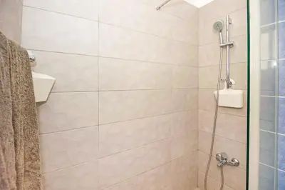 a shower with a glass door in a bathroom at Jules Apartment in Paralimni