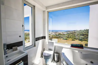 a bathroom with a toilet and a large window at Villa Marilia in Protaras