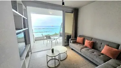a living room with a couch and a view of the ocean at Touch of class Molos Limassol in Limassol