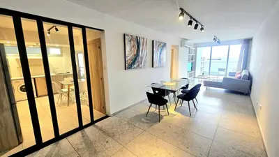 a living room with a dining room table and chairs at Touch of class Molos Limassol in Limassol