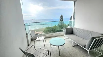 a living room with a couch and chairs and a view of the ocean at Touch of class Molos Limassol in Limassol
