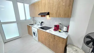 a kitchen with a sink and a washing machine at Antionette Studio Apartment in Limassol