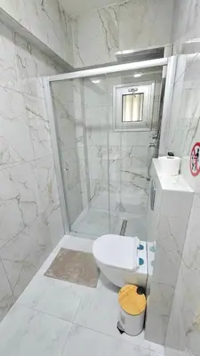 a white bathroom with a toilet and a shower at Antionette Studio Apartment in Limassol