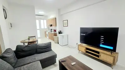 a living room with a couch and a flat screen tv at Antionette Studio Apartment in Limassol