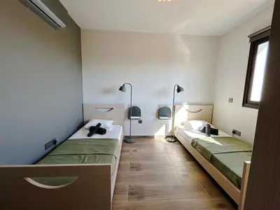 two beds in a room with two lamps at THE A-LINE SEAVIEW MALAMA APARTMENT with pool, tennis court & gym in Paralimni