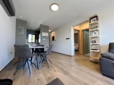 a living room with a table and chairs and a couch at THE A-LINE SEAVIEW MALAMA APARTMENT with pool, tennis court & gym in Paralimni