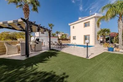 a backyard with a lawn and a pool at Tranquility Villa in Ayia Napa