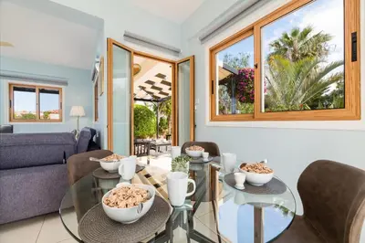 a living room with a glass table and chairs at Tranquility Villa in Ayia Napa