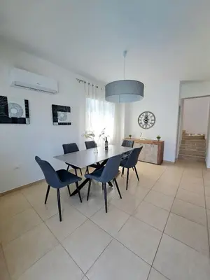 a dining room with a table and chairs at SERENITY PEARL VILLA at the sea in Protaras