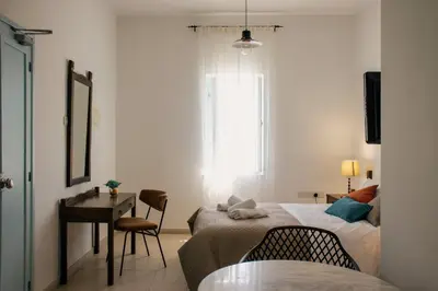 a bedroom with a bed and a desk and a window at Siogkas Inn in Dherinia