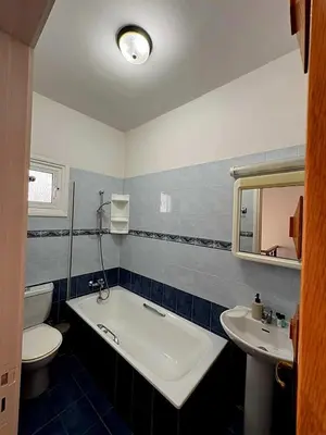 a bathroom with a tub and a toilet and a sink at Villa Solmare in Pervolia