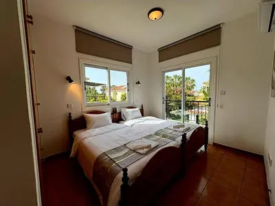 a bedroom with a large bed and two windows at Villa Solmare in Pervolia