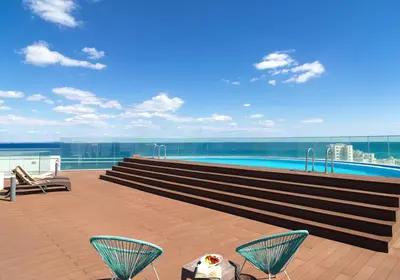 a balcony with chairs and a swimming pool on a building at Suite 1003 at Althea Residence in Larnaka
