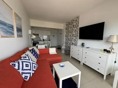 a living room with a red couch and a flat screen tv at Protaras Sunset Bay in Protaras