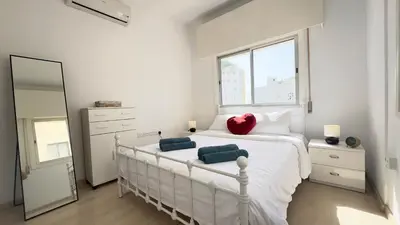 a bedroom with a white bed with a red heart on it at Hills 2bdr Seaside Makenzy Larnaka in Larnaka