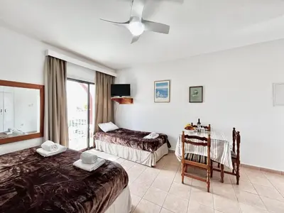a hotel room with two beds and a window at STAY NISSI Chrysland Studios in Ayia Napa