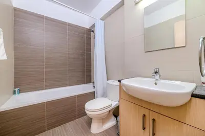 a bathroom with a white toilet and a sink at Mythical Sands Apartment BA09 in Protaras