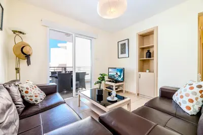 a living room with a couch and a table at Mythical Sands Apartment BA09 in Protaras