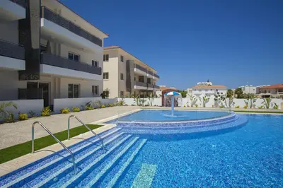a swimming pool in front of a building at Mythical Sands Apartment BA09 in Protaras