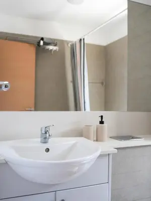 a bathroom with a white sink and a mirror at Mediterranean Escape - Coastal 2-Bedroom Apartment Limassol in Limassol