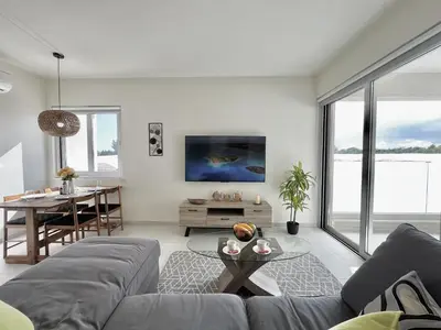 a living room with a couch and a table at STAY Mythical Blue Apartment in Protaras