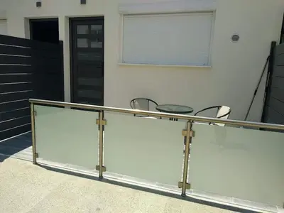 a glass railing with two chairs and a window at Ermioni Apartments in Limassol