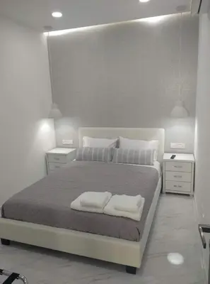 a bedroom with a large bed with two towels on it at Ermioni Apartments in Limassol