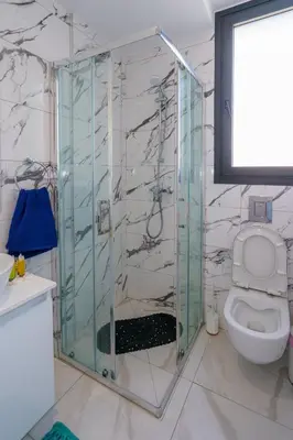 a glass shower in a bathroom with a toilet at Seaview Suite49 steps to Mackenzie Beach Larnaca in Larnaka