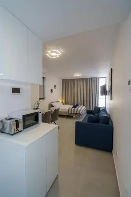 a kitchen and living room with a couch and a bed at Seaview Suite49 steps to Mackenzie Beach Larnaca in Larnaka