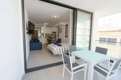 a dining room with a table and a view of a bedroom at Seaview Suite49 steps to Mackenzie Beach Larnaca in Larnaka