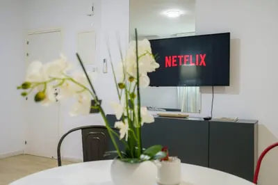 a table with a vase with white flowers on it at Kitieos 163 Suite in Finikoudes in Larnaka