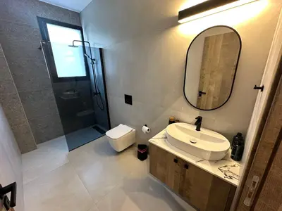 a bathroom with a sink and a mirror and a toilet at 204 Lux Suites Level2 Tower 206 in Nicosia
