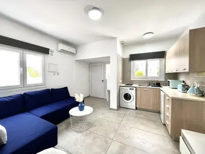 a living room with a blue couch in a kitchen at STAY Napa Ocean Apartment in Ayia Napa